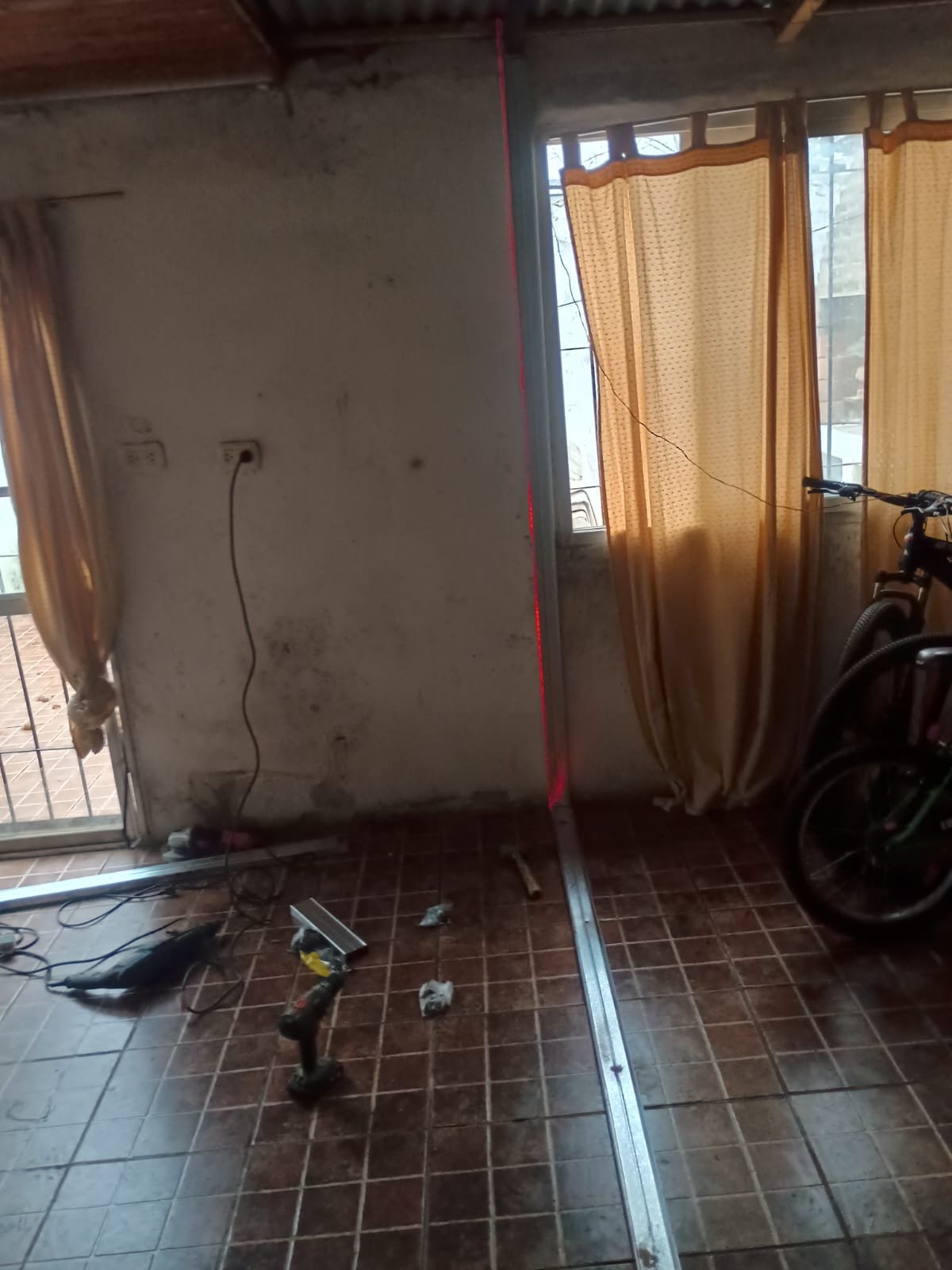 Inicio de obra de tabiquería usando nivel láser para fijación de perfiles galvanizados de Durlock en Rosario