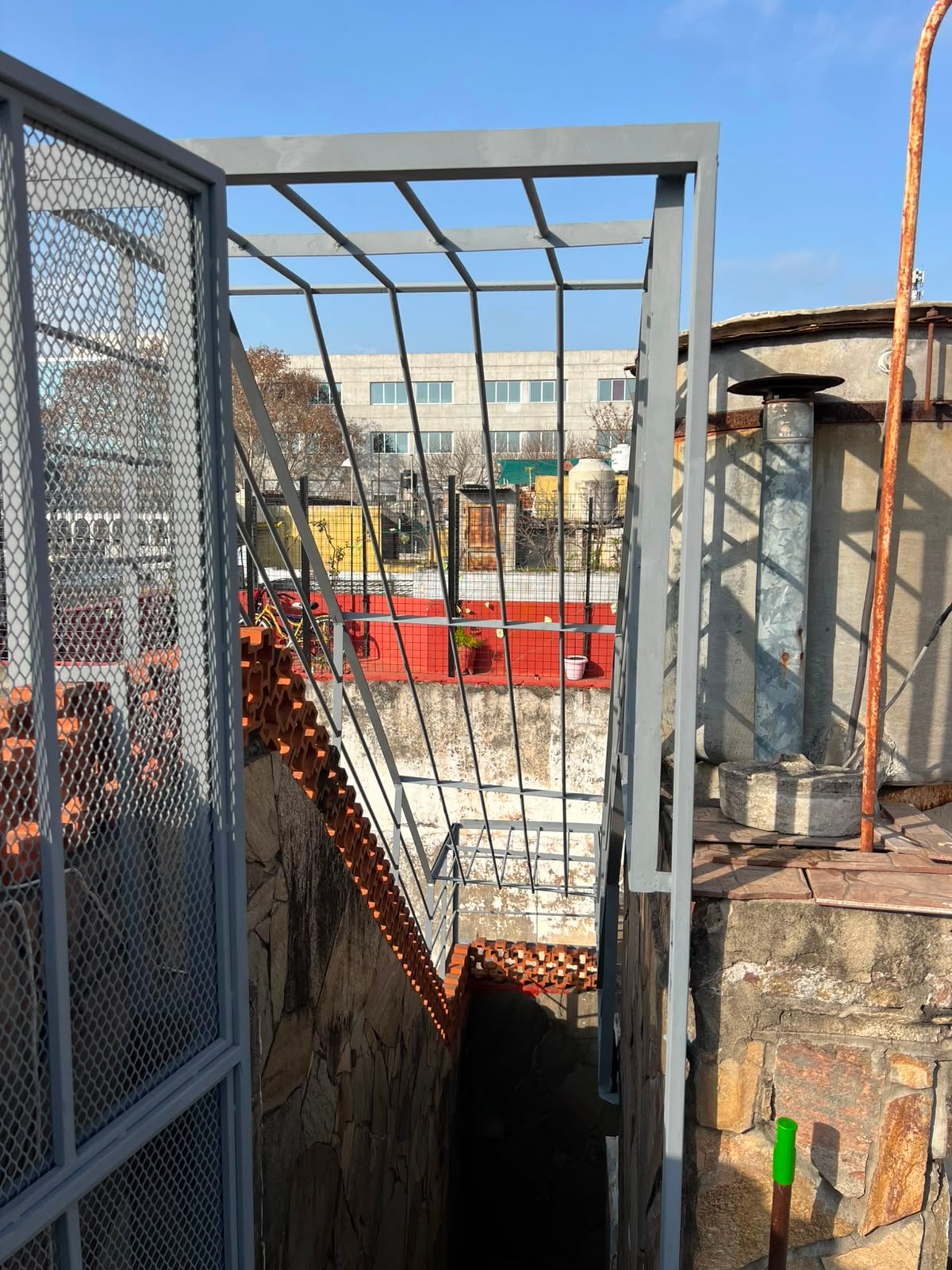 Cerramiento de seguridad para escalera exterior fabricado en hierro y metal desplegado