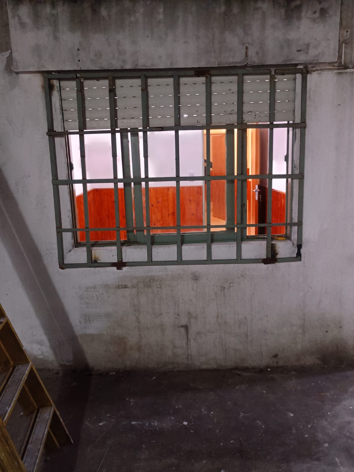 Colocación terminada de reja de seguridad cuadriculada fija sobre ventana exterior