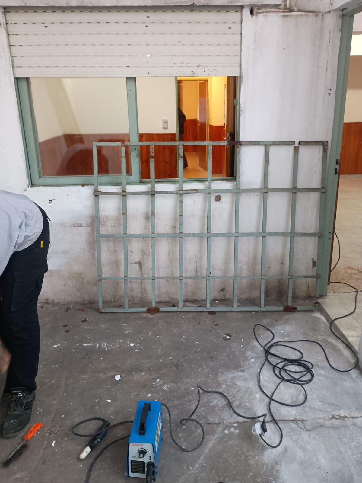 Trabajo de reparación e instalación en obra de reja de protección domiciliaria para ventana